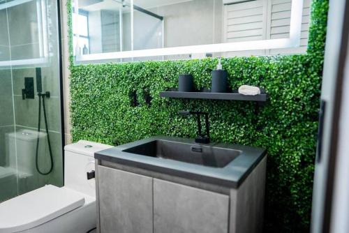 ein Badezimmer mit einem Waschbecken und einer grünen Wand in der Unterkunft Live in style! apartment in North Miami Beach