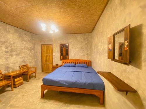 a bedroom with a bed with a blue comforter at Fatima homestay ฟาติมาโฮมสเตย์ in Ban Nam Lat