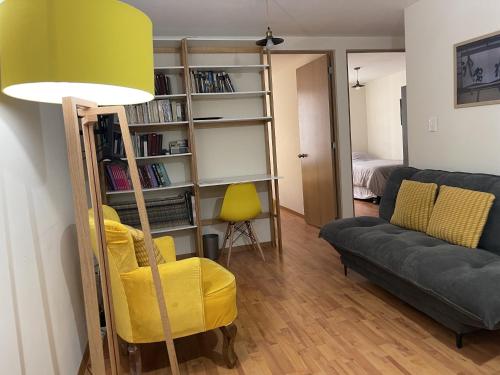 a living room with a yellow chair and a couch at Departamento en Centro Ciudad de México Alameda Reforma in Mexico City