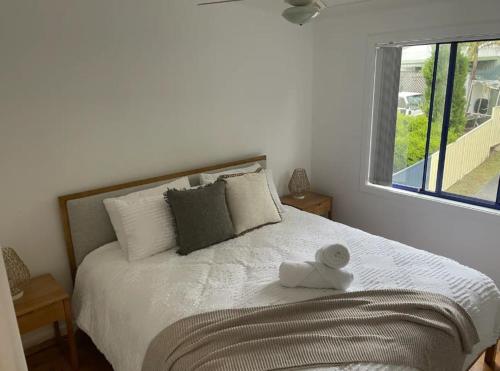 ein Schlafzimmer mit einem Bett mit einem ausgestopften Tier darauf in der Unterkunft Copacabana 4 61 Sandy Point Rd - water views, air con and WiFi in Corlette