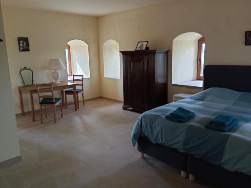 a bedroom with a bed and a table and chairs at Le Nid du Sanglier in Verlaine