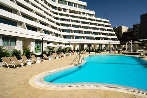 a large building with a large swimming pool in front of a building at Or suite sea side Eilat - אור סויט סי סייד אילת in Eilat