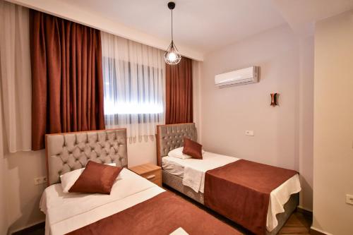 a hotel room with two beds and a window at RED MOON SUITES in Fethiye