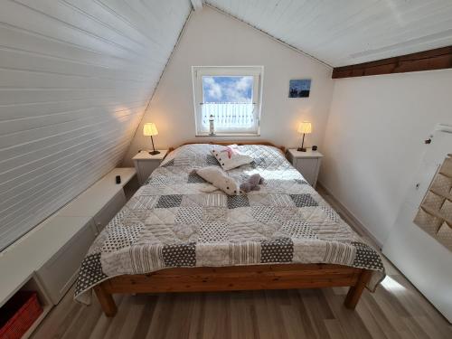 een slaapkamer met een bed met een teddybeer erop bij Ferienhaus Nordsee-Robbe in Eckwarderhörne