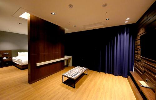 a room with a stage with a bench and a bed at Sea Cruise Hotel in Sokcho