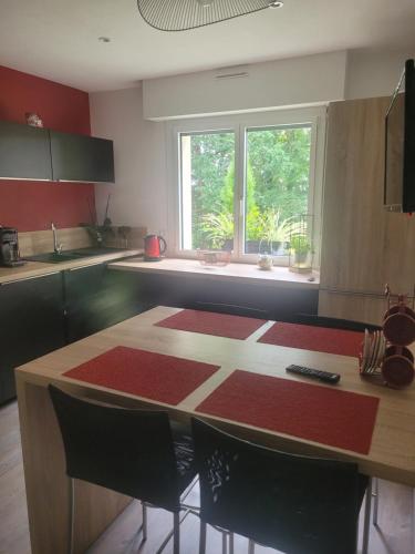 a kitchen with a table with chairs and a window at Campagne à la Ville in Pontivy