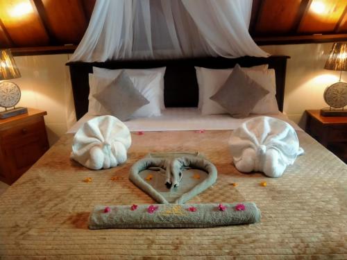 Una cama con dos toallas y dos corazones. en Hakuna Matata Resort Gili Air, en Gili Air