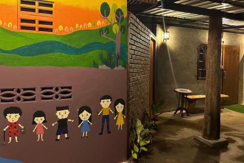 a wall with a family painted on it at Fatima homestay ฟาติมาโฮมสเตย์ in Ban Nam Lat