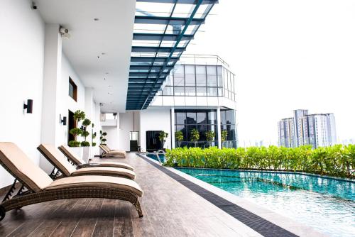 una piscina de hotel con tumbonas y un edificio en Stay @ NOVO Ampang en Kuala Lumpur
