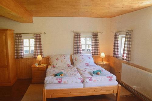 a bedroom with a bed with two lamps and windows at Ferienhaus Masser 