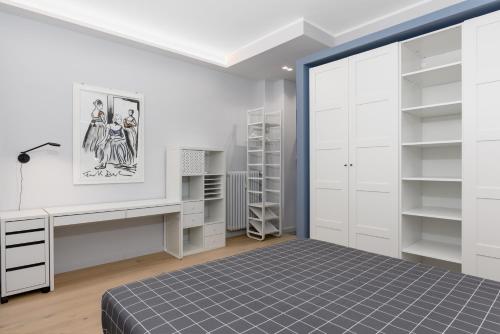 um quarto com uma cama, uma secretária e prateleiras em [Centro Torino] Elegante e Moderno Bilocale em Turim