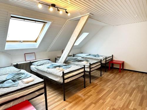 a group of beds in a room with a window at Spacious & Cozy Apartments in Krefeld