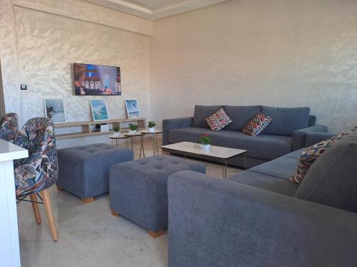 un soggiorno con divani e tavoli blu di vacance et confort les sablettes a Mohammedia