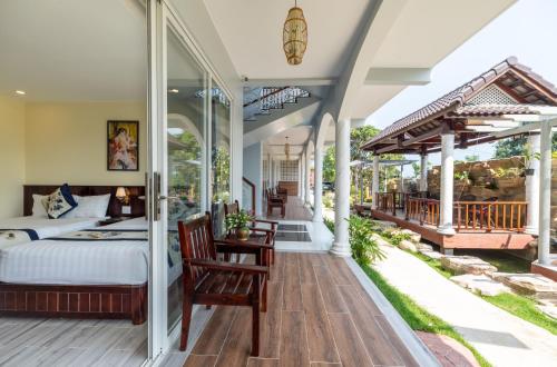 een grote slaapkamer met een bed en een balkon bij Suối Mây Phú Quốc Garden Resort - Full 24h Stay in Phu Quoc
