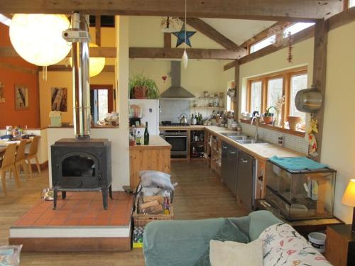 Beautiful Award-Winning Rural Home في Dolphinton: مطبخ وغرفة معيشة مع موقد