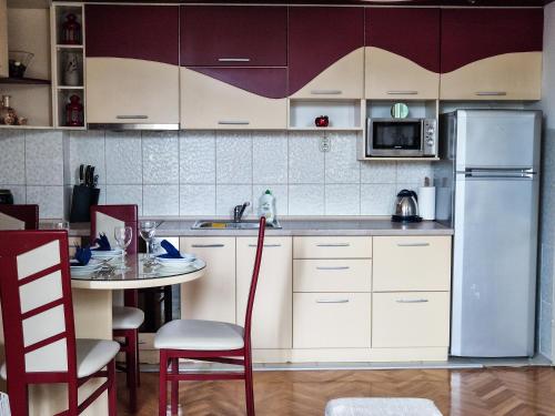 a kitchen with a table and a refrigerator at Boulevard Apartments in Kumanovo