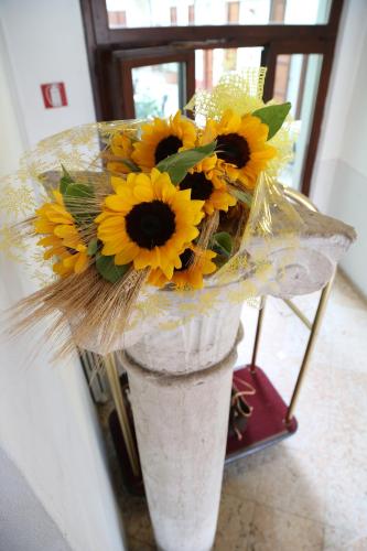 a vase with yellow sunflowers in it at Hotel Antica Dimora, MantegnaHotels in Mantova