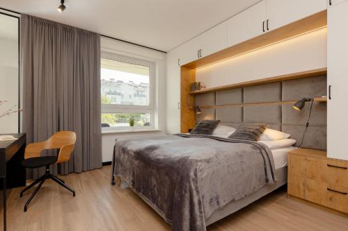 um quarto com uma cama grande, uma secretária e uma janela em Warsaw Piaseczno Stylish Apartment with Parking by Renters em Piaseczno