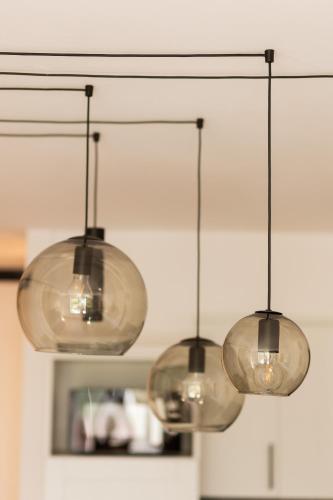 three lights hanging from a ceiling in a kitchen at Warsaw Piaseczno Stylish Apartment by Noclegi Renters in Piaseczno
