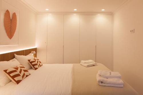een slaapkamer met een bed met handdoeken erop bij FLH Alluring Design Apartment S Bento in Lissabon