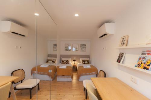 een kamer met 4 bedden en een tafel en stoelen bij FLH Alluring Design Apartment S Bento in Lissabon