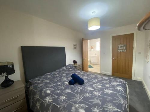 a blue stuffed animal sitting on a bed in a bedroom at Swansea city center flat parking in Swansea