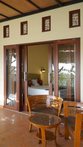 a room with a table and chairs and a bed at Vamana Bangsal in Pawenang