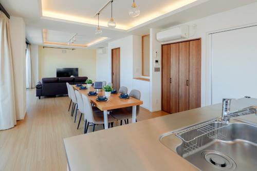 a kitchen and living room with a long table in a room at Kiyosumi SOHO in Tokyo