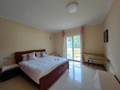 a bedroom with a large bed and a window at Valley Oasis Villa in Enshi