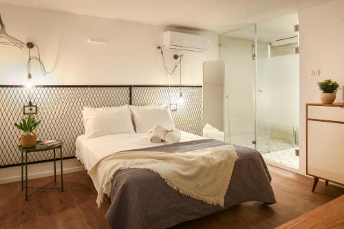 um quarto com uma cama e uma cabina de duche em vidro em The Carmel House - Aparthotel in Kerem Hateimanim By Sea N' Rent em Tel Aviv