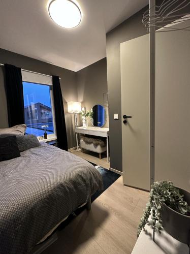 um quarto com uma cama, uma janela e uma porta em Nytt og flott hus i Haugesund 