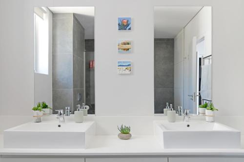 ケープタウンにあるNaomi - Designer Penthouse in the Heart of Cape Townの白いバスルーム(シンク2台、鏡付)