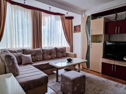 Boulevard Apartments في كومانوفو: غرفة معيشة مع أريكة وطاولة