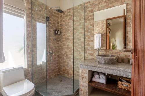 a bathroom with a toilet and a glass shower at Designer Studio Emy Sanur in Sanur