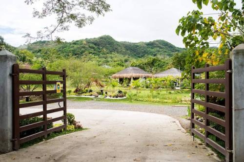 a gate leading to a garden with mountains in the background at Entire farm place w/ 2 casitas & dipping pool in Lubo