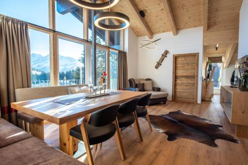 a dining room with a wooden table and chairs at Ferienwohnung 73 - Smaragd in Wald im Pinzgau