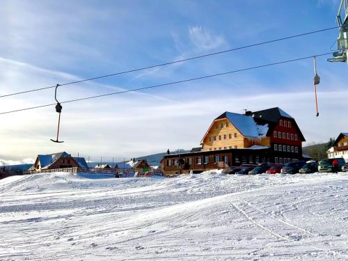 a ski resort with a ski lift in the snow at Wellness Resort Bouda Malá Úpa in Horní Malá Úpa