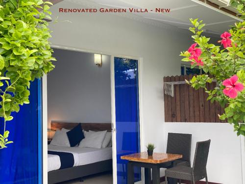 a room with a bed and a table and a bed and a room with at Tides Dhigurah in Dhigurah