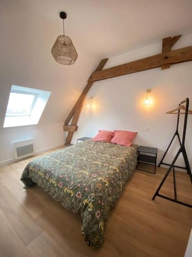 a bedroom with a bed in a room with a window at Domaine de La Quenouille - Appartement B in Péronne