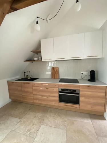 a kitchen with white cabinets and a sink at Domaine de La Quenouille - Appartement B in Péronne