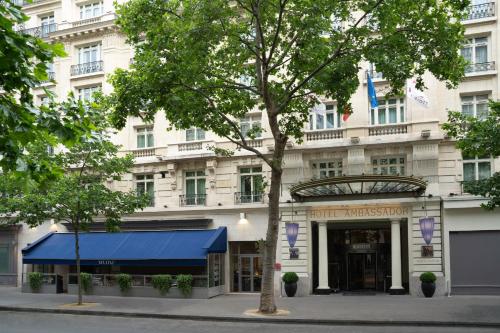 a building with a blue awning in front of it at Paris Marriott Opera Ambassador Hotel in Paris