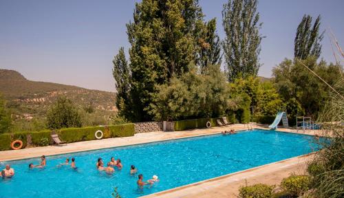 um grupo de pessoas numa piscina em Casa rural el Carmen em Prado del Rey