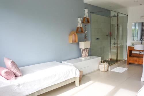 a bedroom with a bed and a glass shower at La Balise Marina by Horizon Holidays in Tamarin