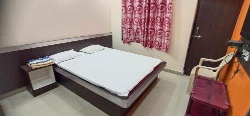 מיטה או מיטות בחדר ב-OYO Flagship Shri Anasuya Datt Lodge