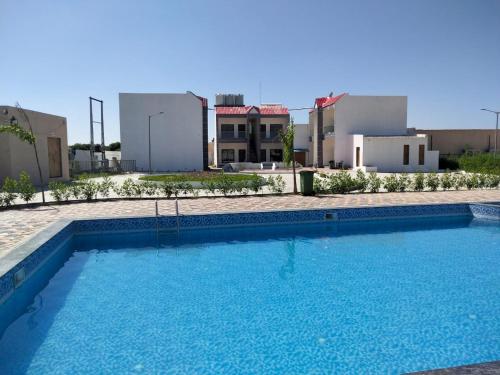 a large blue swimming pool with buildings in the background at Amazing Fun World By Nexottel in Dwarka