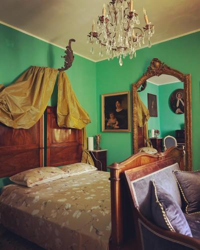 una camera da letto con pareti verdi e un letto con specchio di Art action room 