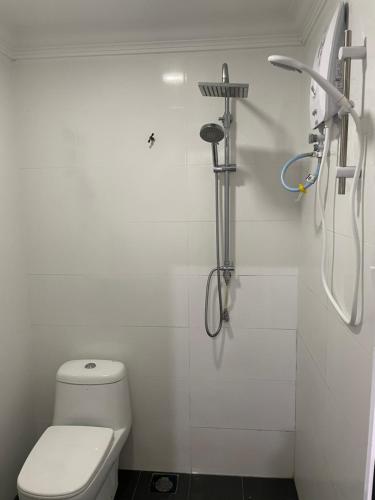 a white bathroom with a toilet and a shower at Kundang Villa @ Tasik Biru - 3 Bedrooms Bungalow in Rawang