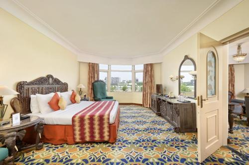 a hotel room with a bed and a desk at The Cama - A Sabarmati Riverfront Hotel in Ahmedabad