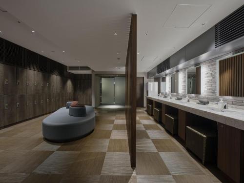 a bathroom with two sinks and a bench in the middle at Villa Fontaine Grand Osaka Umeda in Osaka