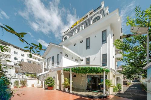a white building with an arch in a courtyard at VMT Hotel Da Lat in Da Lat